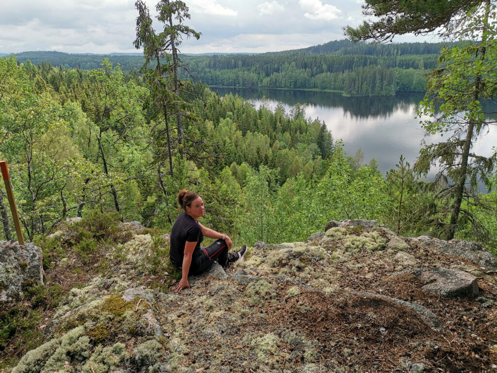 En person njuter av utsikten högt uppe på berget, över sjön Matlången, vandringsleden Jörnsjöleden passerar platsenärnsjöleden