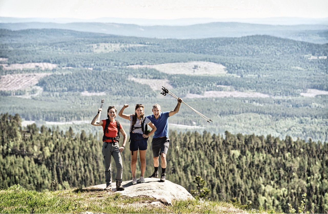 Tre människor som har vandrat och står på The Lodge