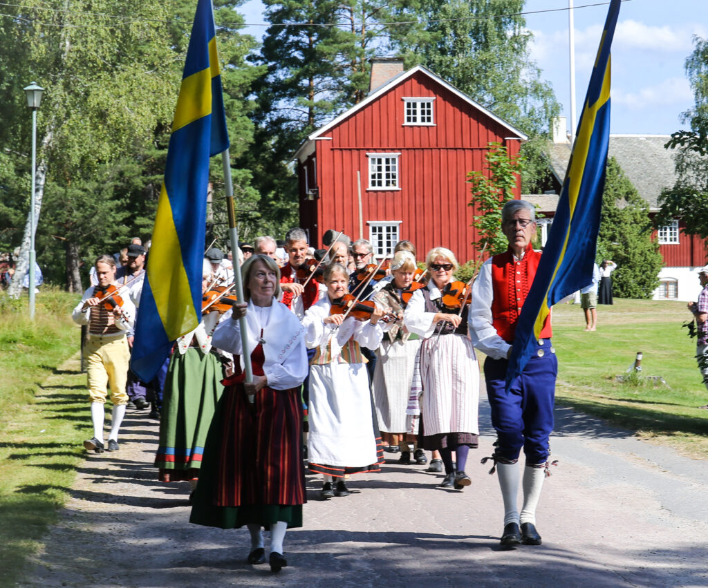 Parade with people in folk costumes playing folk music